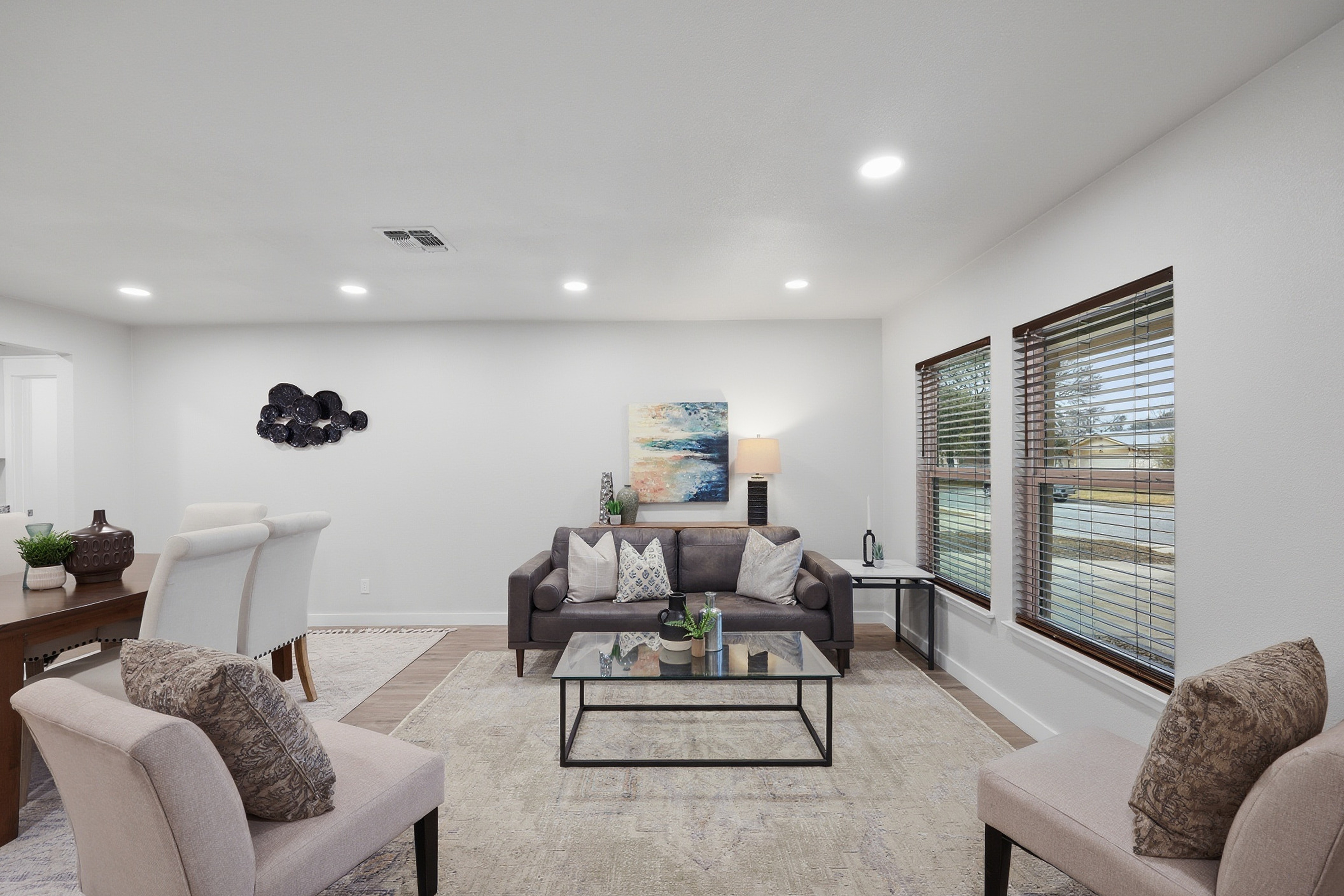 Front living room with recessed lighting, sofa, armchairs, and luxury vinyl plank floors